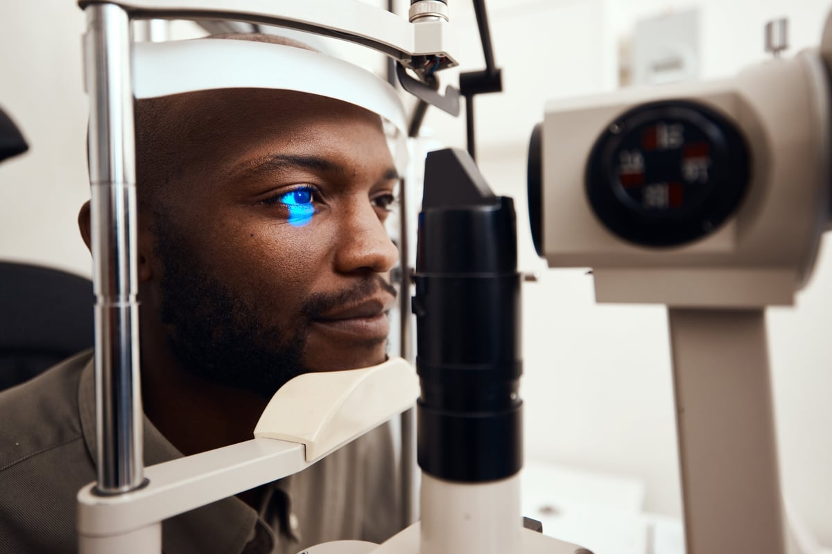 Shot of a young man getting his eye's examined with a slit lamp